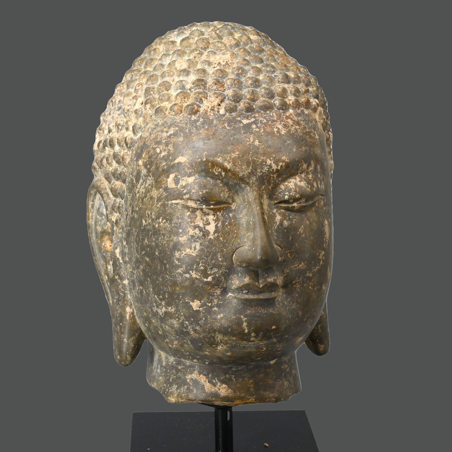 A Chinese Grey Limestone Head of a Buddha, Shandong Province, Northern Qi dynasty, ca. 550 - 577 CE