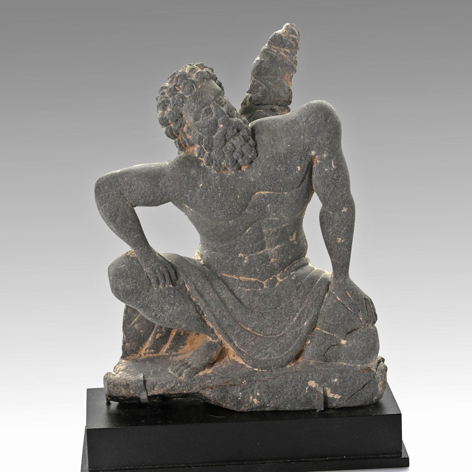 A Gandharian Gray Schist Figure of a Kneeling Atlas, ca. 2nd - 4th century CE