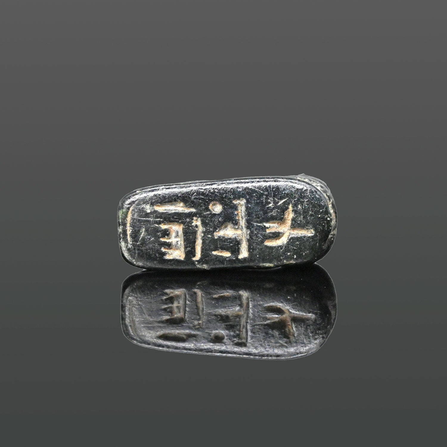 An Egyptian Serpentine Inscribed Scaraboid of a Recumbent Ram, 18th Dynasty, ca. 1550 - 1295 BCE