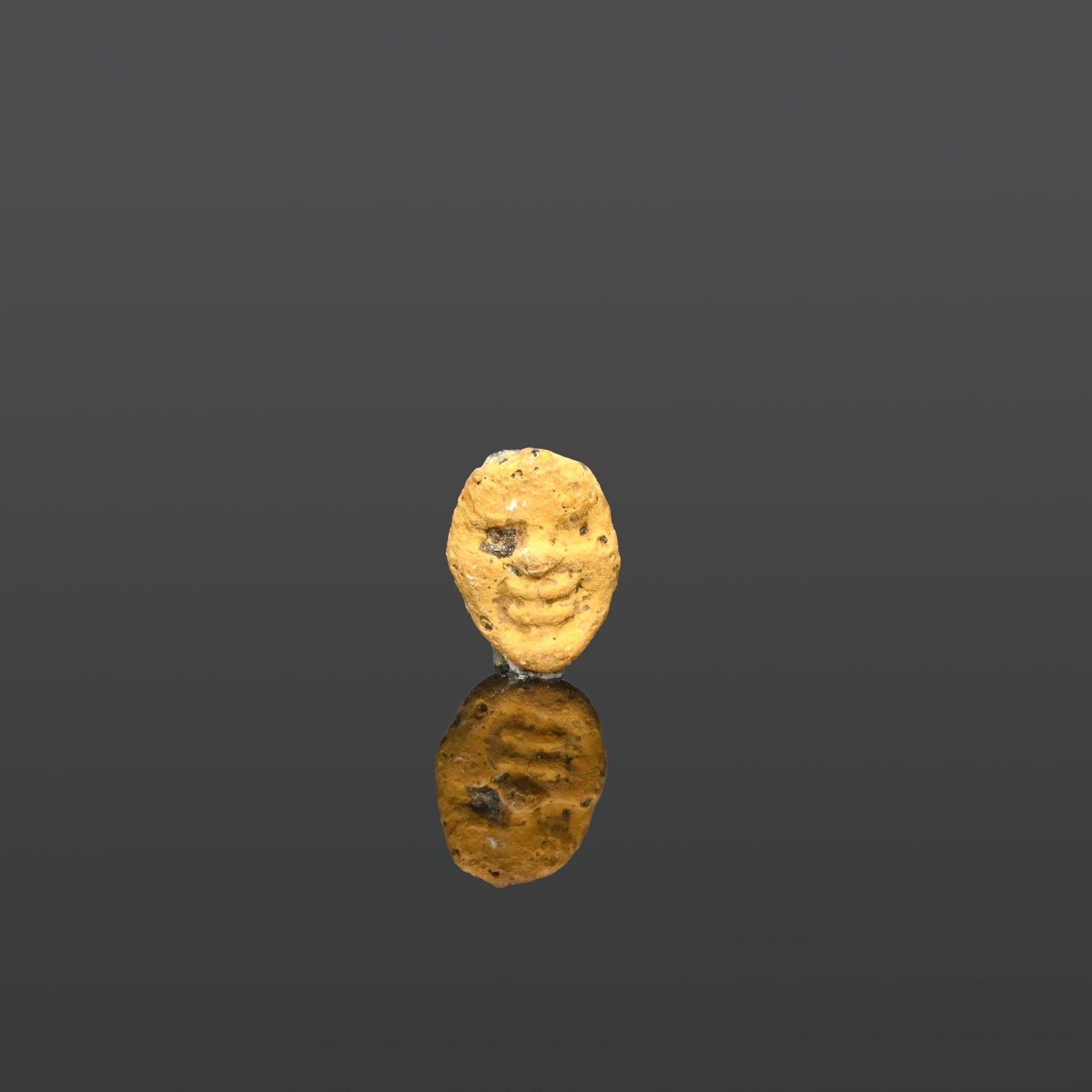 A Phoenician Yellow Glass Face Pendant, ca. 3rd - 1st century BCE
