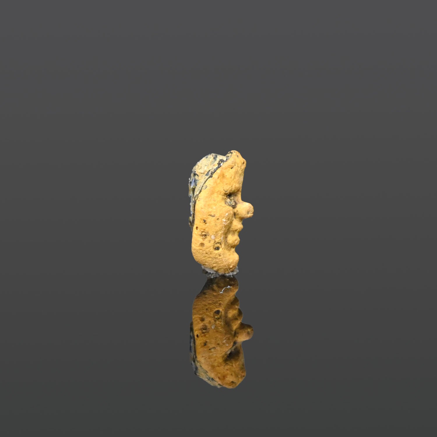 A Phoenician Yellow Glass Face Pendant, ca. 3rd - 1st century BCE