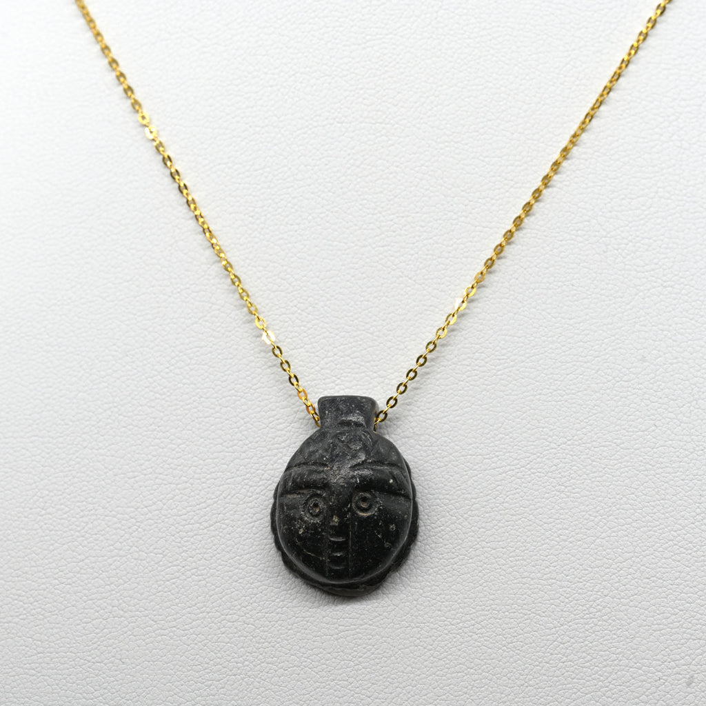 A Coptic Basalt Face Pendant, Coptic Period, ca. 3rd - 7th century CE