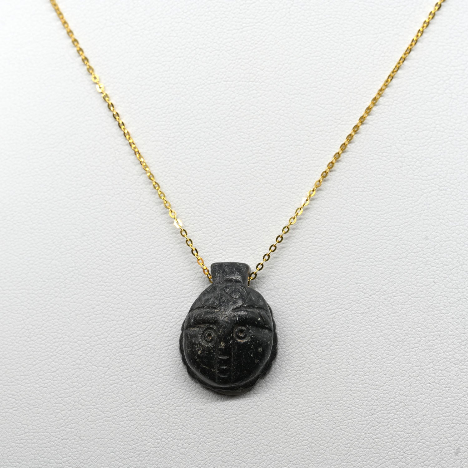 A Coptic Basalt Face Pendant, Coptic Period, ca. 3rd - 7th century CE