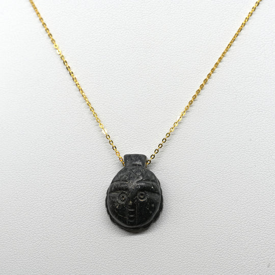 A Coptic Basalt Face Pendant, Coptic Period, ca. 3rd - 7th century CE
