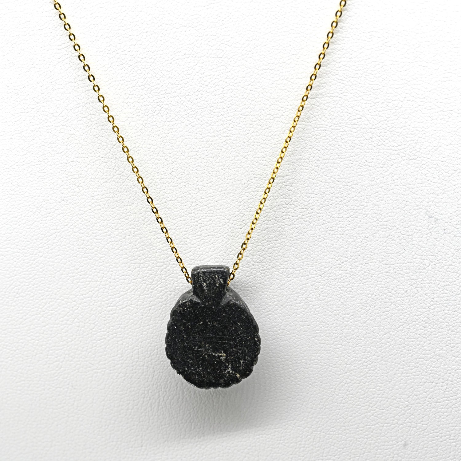 A Coptic Basalt Face Pendant, Coptic Period, ca. 3rd - 7th century CE