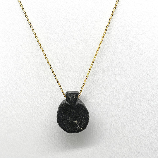 A Coptic Basalt Face Pendant, Coptic Period, ca. 3rd - 7th century CE