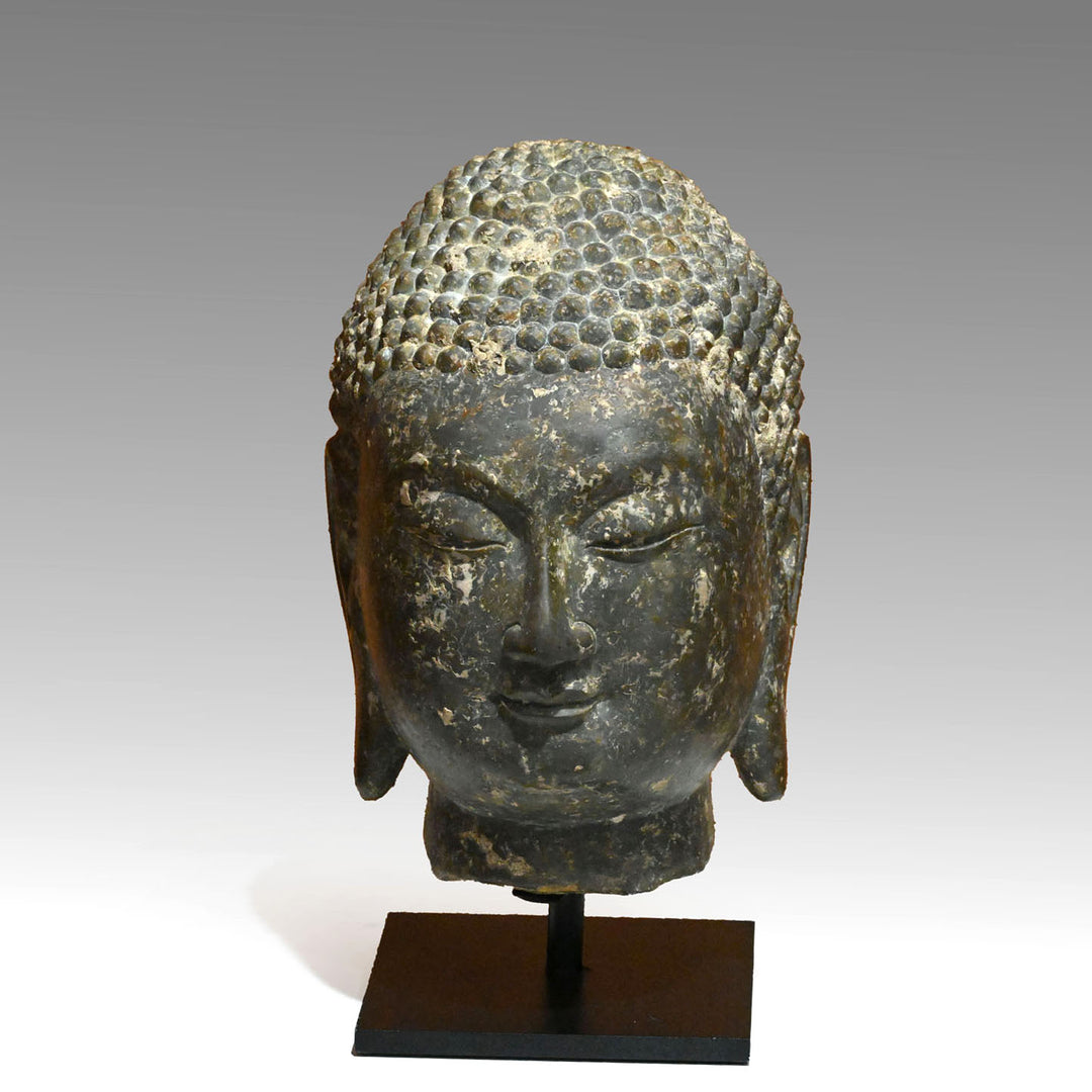 A Chinese Grey Limestone Head of a Buddha, Shandong Province, Northern Qi dynasty, ca. 550 - 577 CE