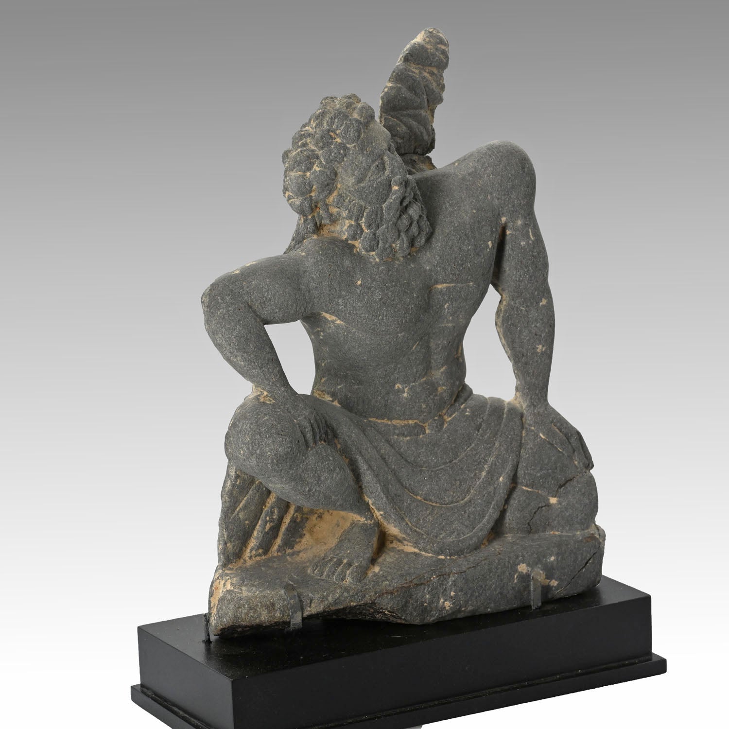 A Gandharian Gray Schist Figure of a Kneeling Atlas, ca. 2nd - 4th century CE