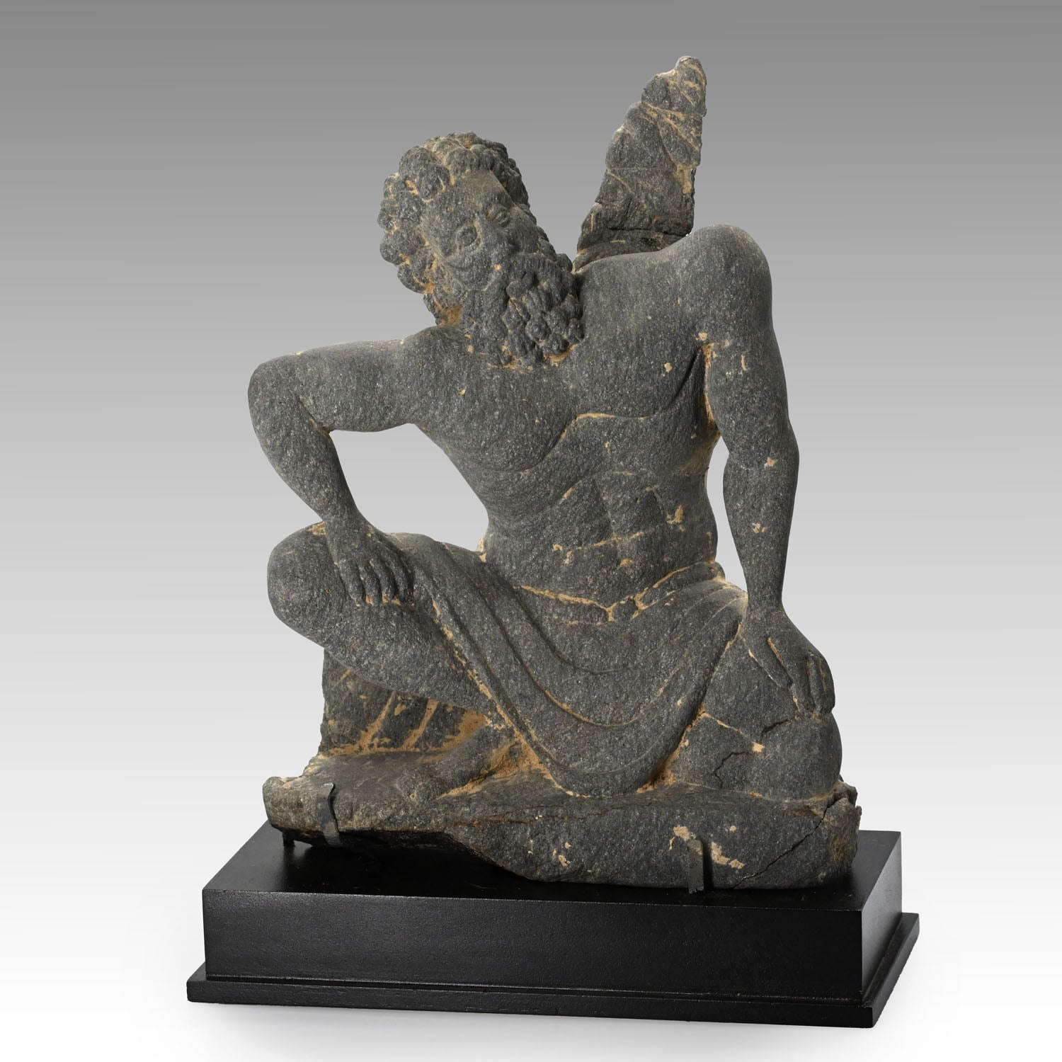 A Gandharian Gray Schist Figure of a Kneeling Atlas, ca. 2nd - 4th century CE