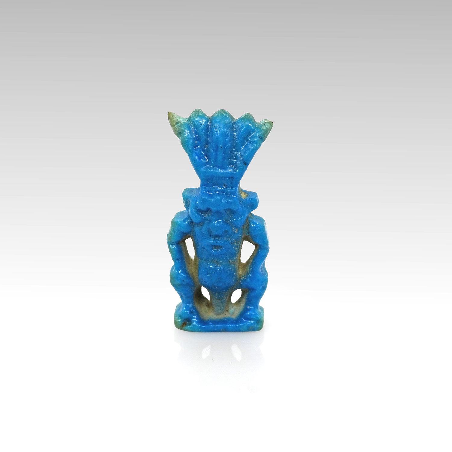 An Egyptian bright blue faience Bes amulet, New Kingdom, 1539-1077 BCE