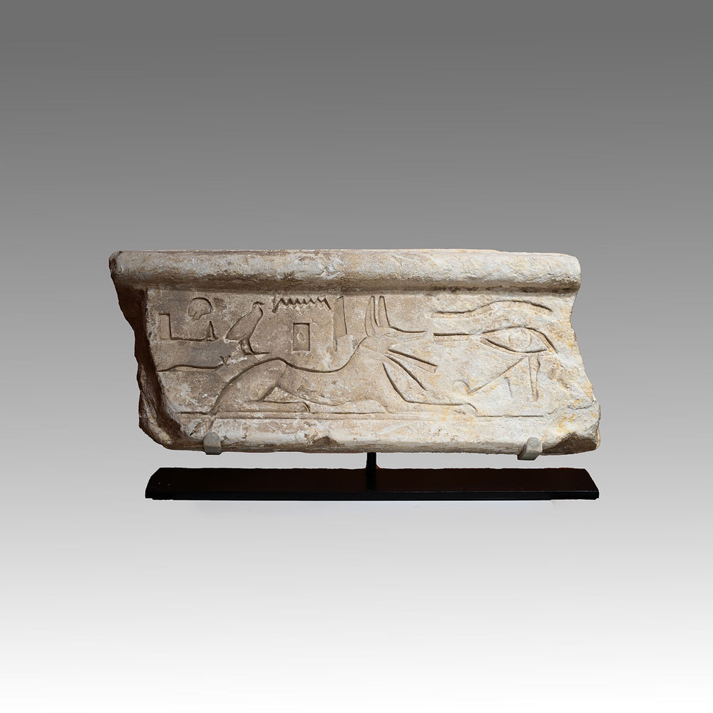 An Egyptian Limestone Relief fragment with Wedjet Eye and Anubis, New Kingdom, 18th Dynasty, ca. 1540 - 1292 BCE