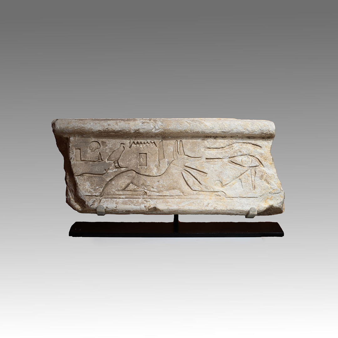 An Egyptian Limestone Relief fragment with Wedjet Eye and Anubis, New Kingdom, 18th Dynasty, ca. 1540 - 1292 BCE