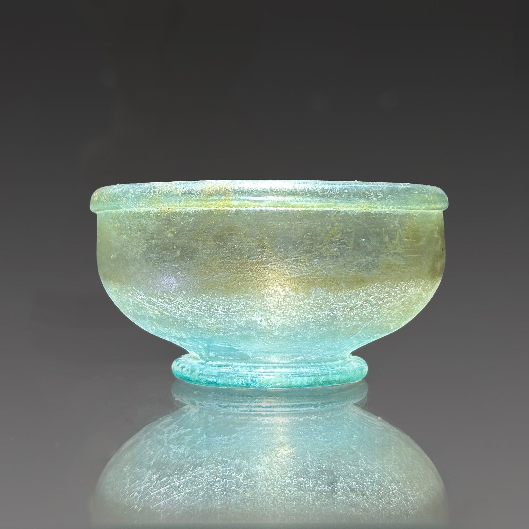 A small Roman Blue-Green Glass Bowl with Foot, Roman Imperial Period, ca. 3rd century CE
