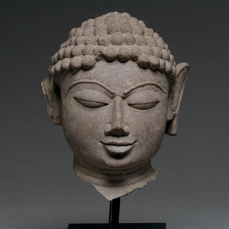A mottled red sandstone head of a Jina, India, 11th/12th century CE - Sands of Time Ancient Art