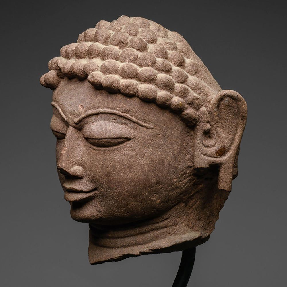 A mottled red sandstone head of a Jina, India, 11th/12th century CE - Sands of Time Ancient Art