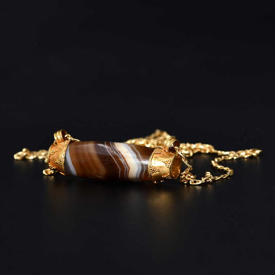 A Western Asiatic Banded Agate Bead & Gold Cap Pendant, ca mid 1st millennium BCE