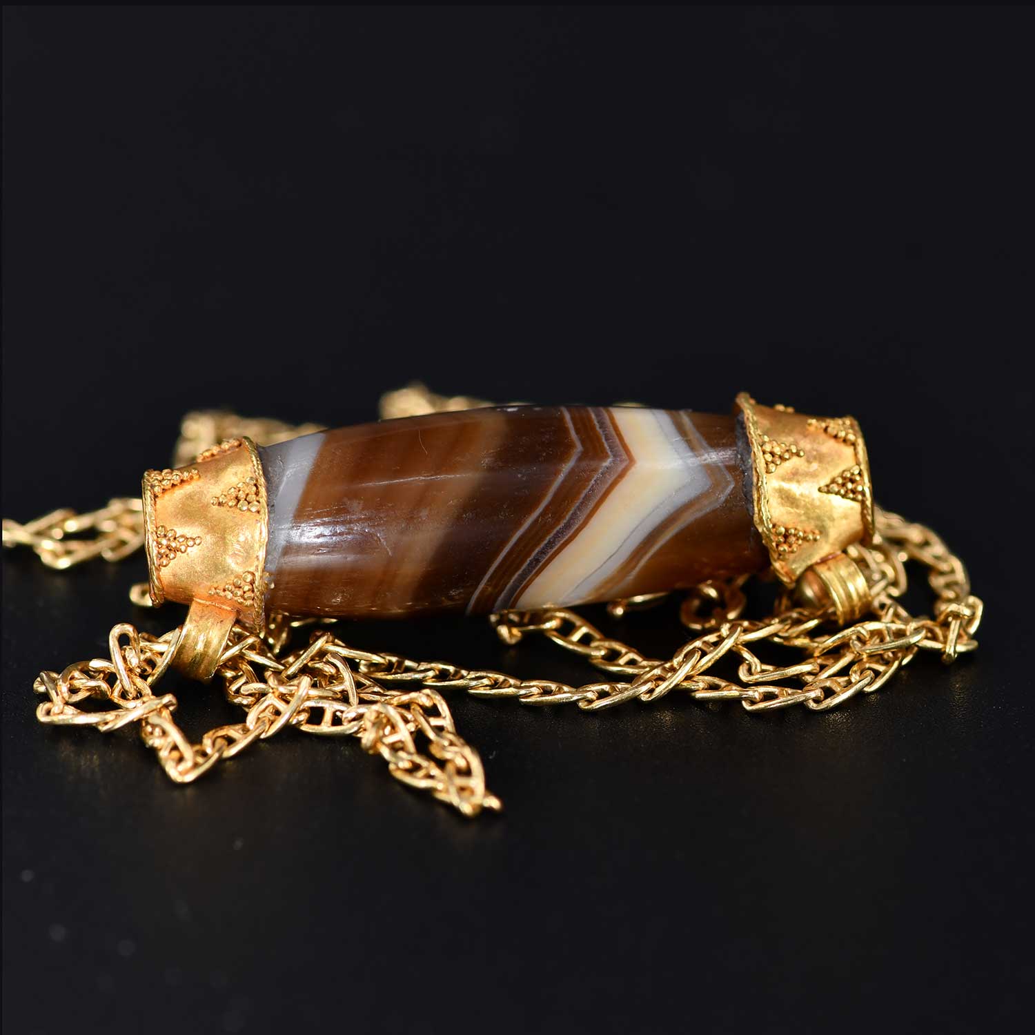 A Western Asiatic Banded Agate Bead & Gold Cap Pendant, ca mid 1st millennium BCE