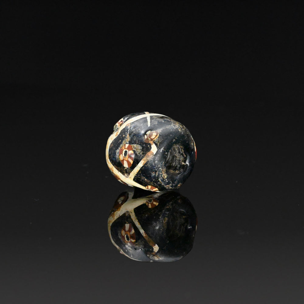 A large Islamic Glass Eye Bead with trails, ca. 12th - 14th century CE